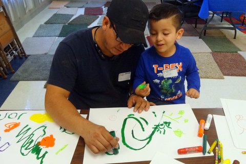 A father and son draw with the supplies they received from Smart Start
