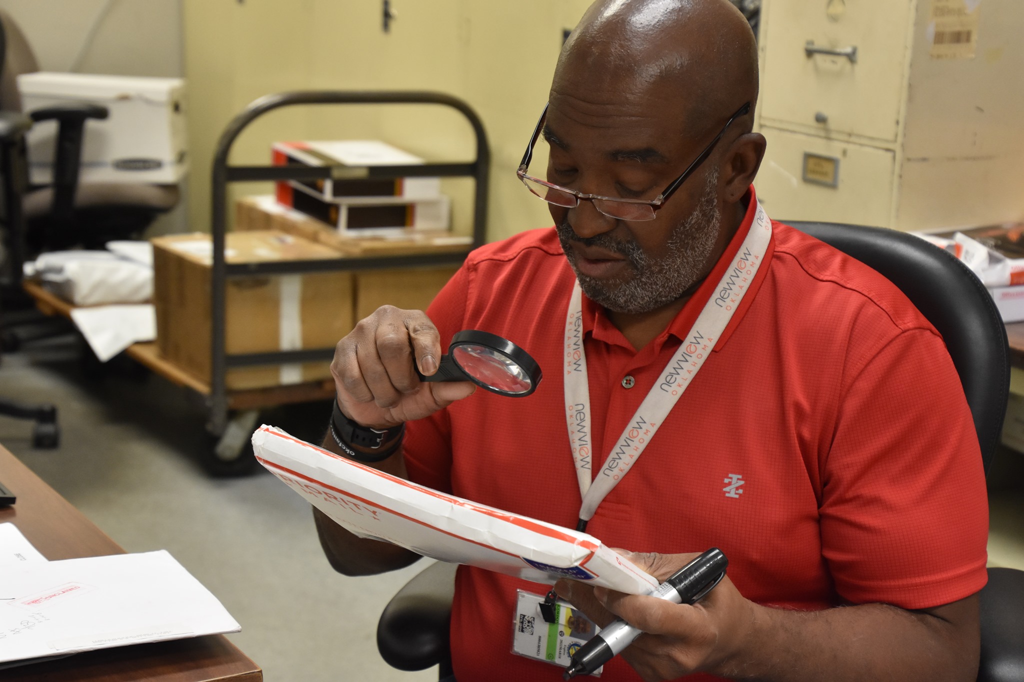 A low vision NewView employee is shown sorting mail at one of our mail room operations.