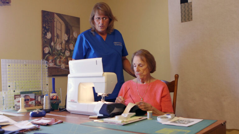 A NewView staff member is featured helping a client test new lighting in her home.