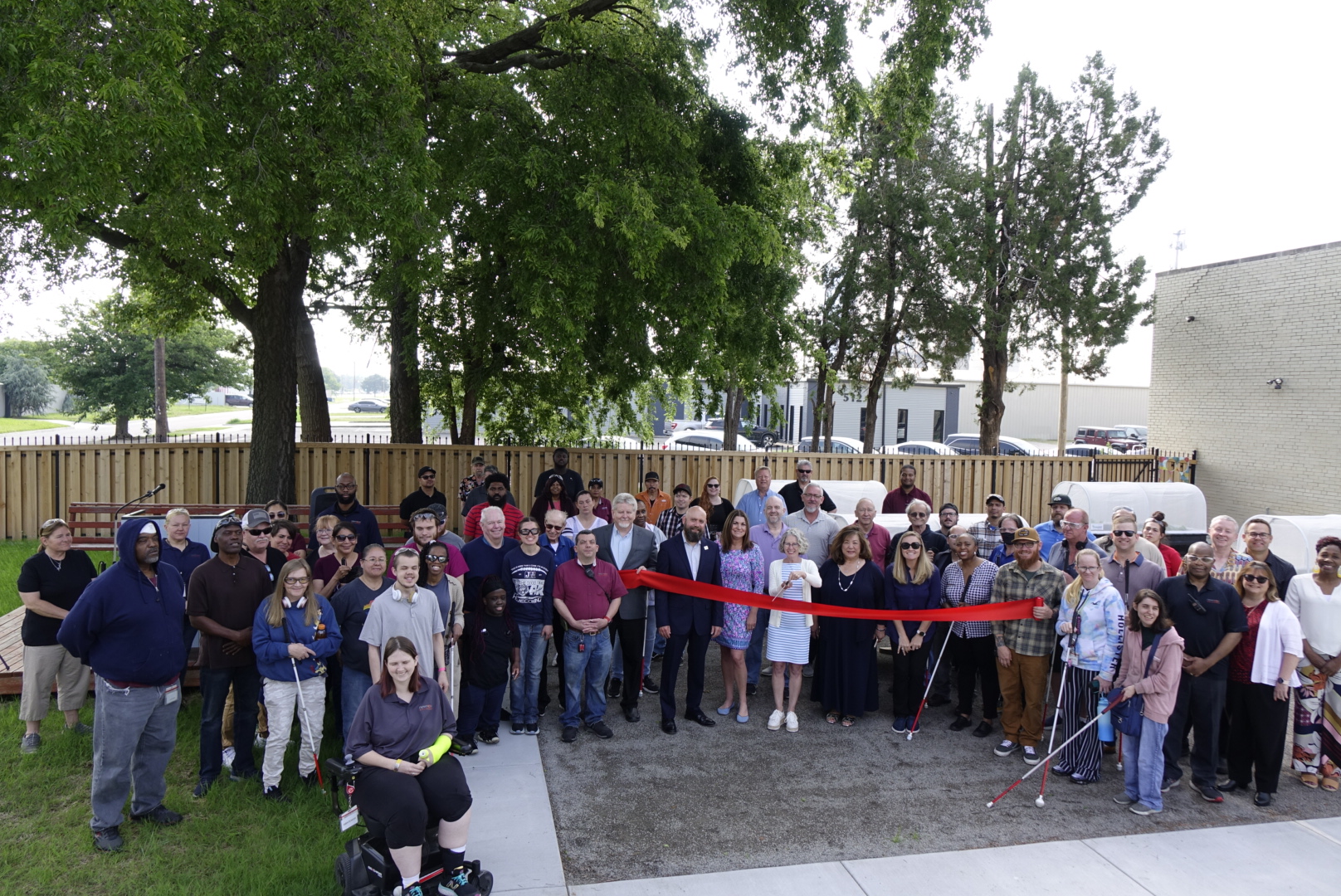 NewView's manufacturing employees gather together to celebrate the opening of the accessible garden and walking path