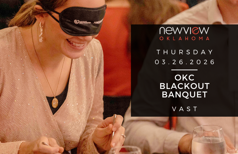 Woman who has on a blindfold enjoys dinner at a recent Blackout Banquet.