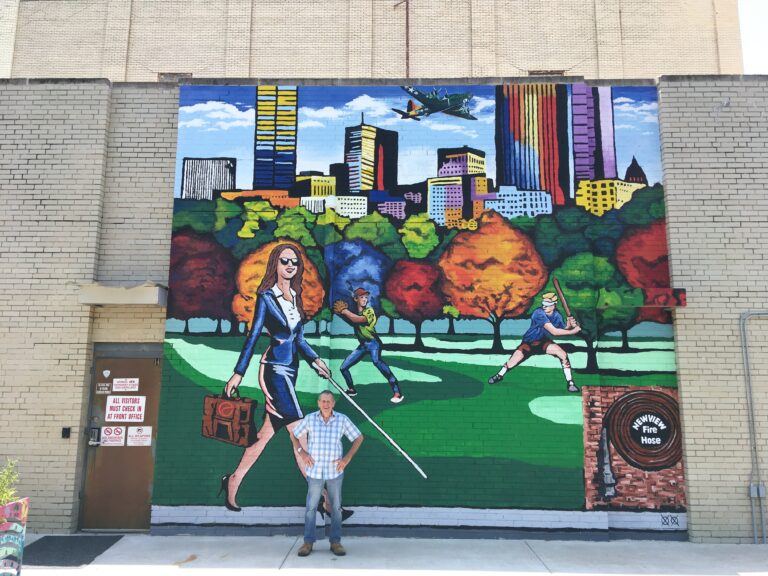 man posing in front of mural