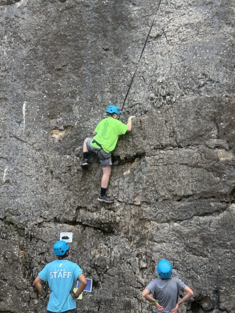Camper climbing a rock mountain wall.