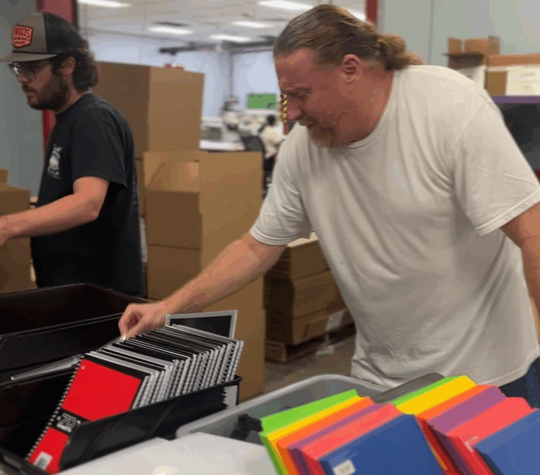 NVO employees putting together school supply filled backpacks
