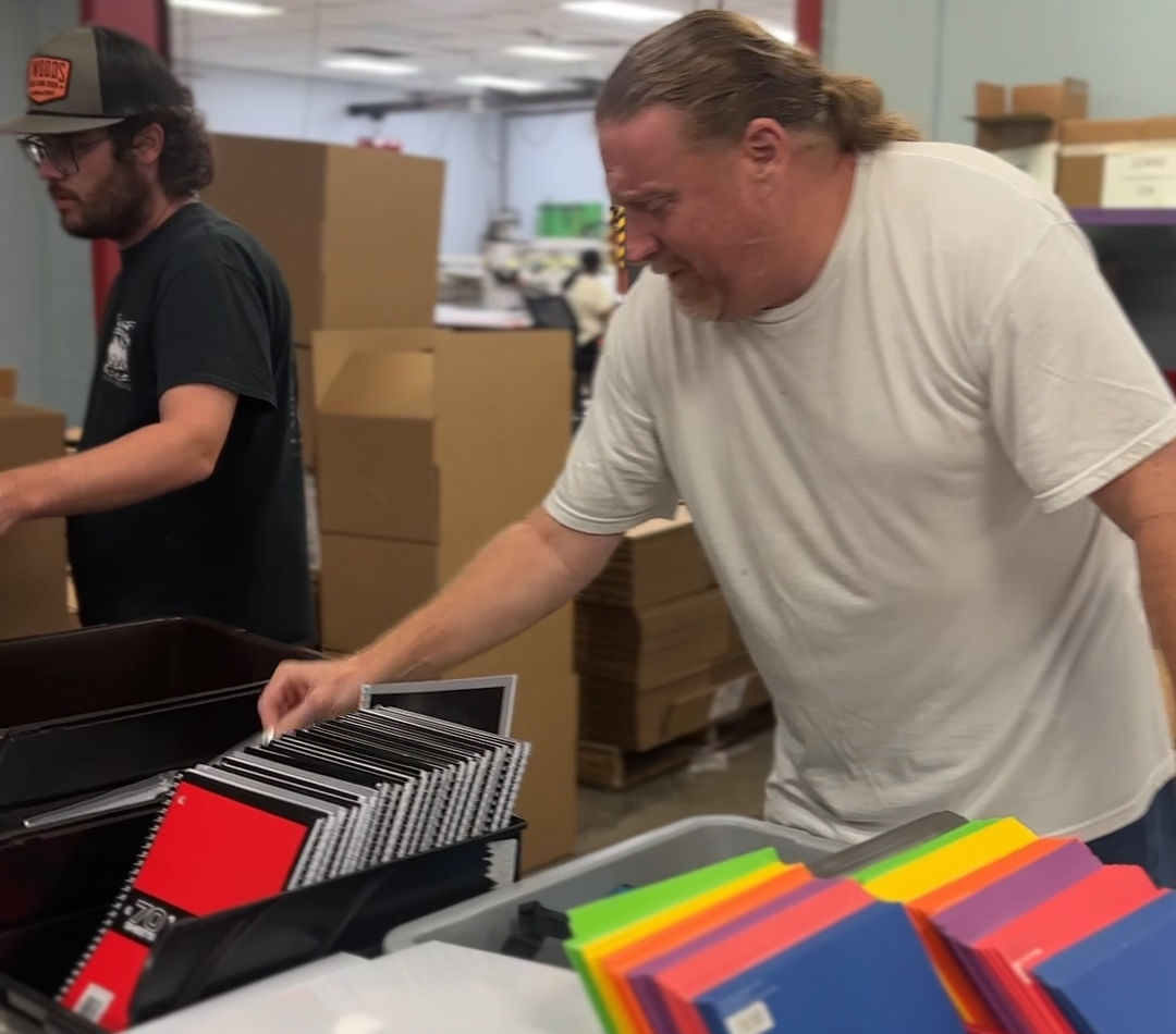NVO employees putting together school supply filled backpacks