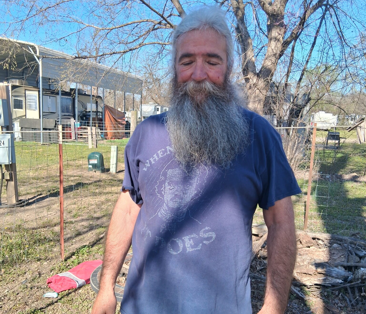 An image of Jason standing in his backyard on a beautiful blue sky day.
