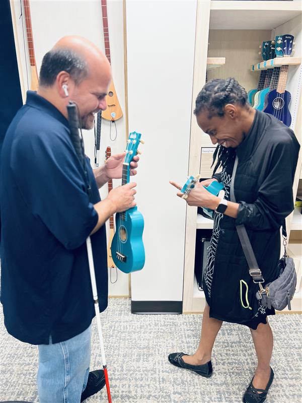 People playing strum guitars in the Music Lab