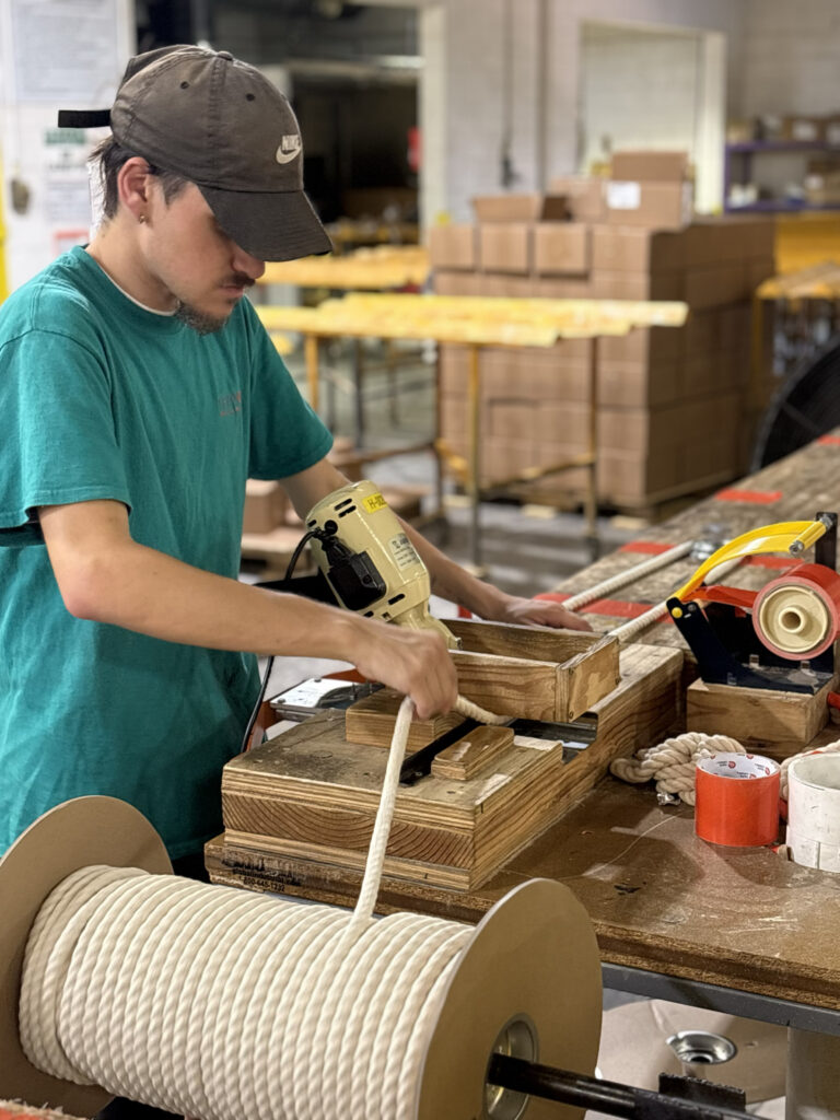 Man with a ball cap measuring rope.