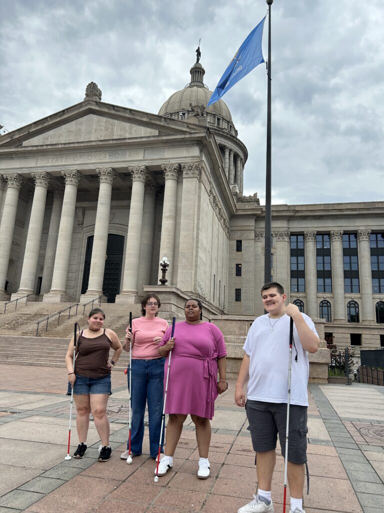 group standing smiling in front of the capital building