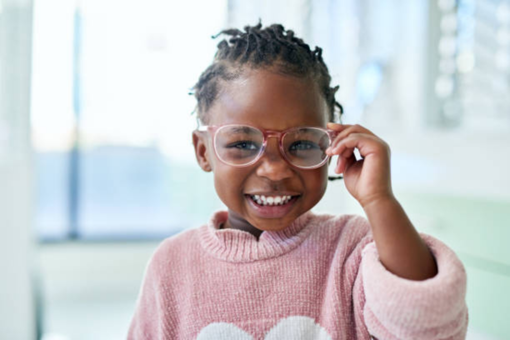 smiling child wearing pink glasses